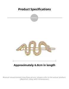 Détail d'une pince à cheveux serpent dorée de 6,8 cm ornée de strass brillants sur blanc