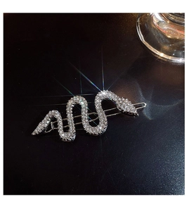 Barrette serpent argentée étincelante avec strass blancs sur fond sombre élégant
