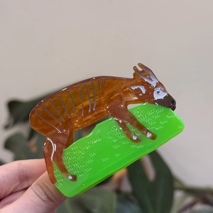 Artistic animal shape acetate hair claw clip in brown and green for elegant hairstyling