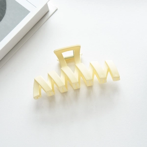Macro shot of cream matte wavy hair claw clip showing durable metal spring and modern design
