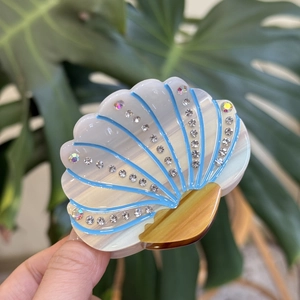 Elegant shell-shaped hair claw clip with rhinestones and blue sea shell pattern