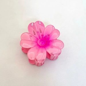 Détail d'une pince à cheveux en forme de fleur rose dégradé avec des pétales acryliques