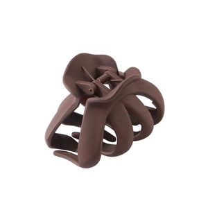 Gros plan sur la pince à cheveux mate chocolat avec design à griffes multi-imbriquées