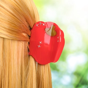 Pince à cheveux rouge en forme de piment avec strass portée sur cheveux blonds