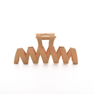 Matte apricot large claw clip with hollow wavy design for elegant hair styling
