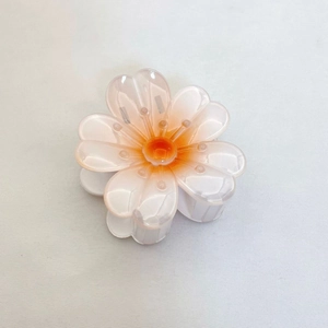 Vue détaillée de la pince à cheveux plumeria avec dégradé de rose et d'orange