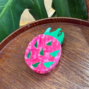 Creative dragon fruit hair claw in vibrant pink acetate with tropical leaf design