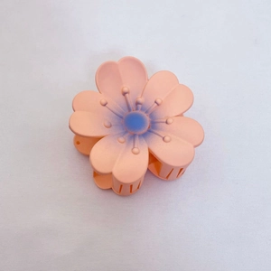 Détail d'une pince à cheveux fleur de cerisier rose corail mat avec dégradé violet central
