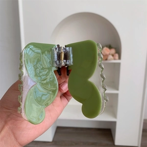 Close-up of green butterfly hair claw clip with acetate finish and gold metal spring