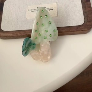 Détail de la pince à cheveux champignon avec strass verts et papillon en marbre