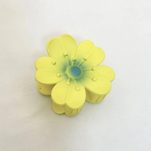 Pince à cheveux tournesol jaune avec dégradé bleu-vert pour femme sur tissu blanc