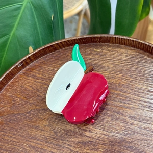 Macro view of creative apple-shaped hair claw clip with glossy finish and green leaf detail