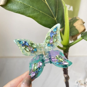Detail view of butterfly hair claw with emerald acetate and multicolor rhinestones