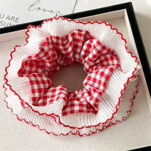 Detail of red checkered and white pleated lace scrunchie in a premium gift box