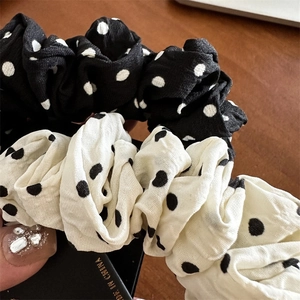 Gros plan de chouchous à pois noirs et blancs montrant la texture du tissu et les plis