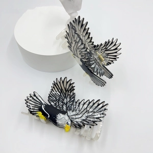 Pinces à cheveux en forme d'aigle en noir et blanc avec détail de bec jaune