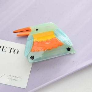 Close-up of bird-shaped acetate hair claw clip with colorful patchwork design