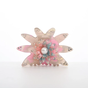 Pince à cheveux fleur en acétate rose avec perle et strass sur fond blanc