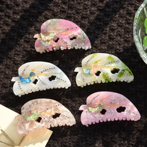 Set of five acetate hair claws with rhinestone butterfly patterns on velvet
