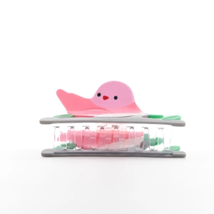 Close-up of pink bird hair claw clip with green leaf detail and acetate resin finish