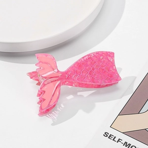 Detail of pink acetate mermaid tail hair claw clip featuring intricate scale texture