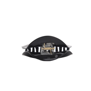 Detail view of a black high-gloss hair claw clip showing the metal spring and teeth