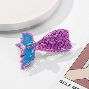 Detail view of purple mermaid tail hair claw clip with blue fins and scale pattern