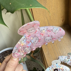 Dettaglio molletta per capelli a gatto rosa traslucido con finitura glitterata