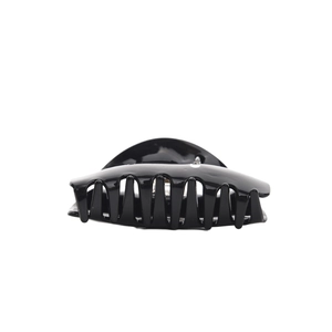 Macro detail of large glossy black hair claw clip with polished finish and strong spring