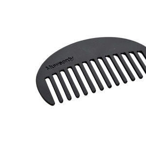 Detail of a black acetate hair comb with star patterns and Muwaordly brand logo