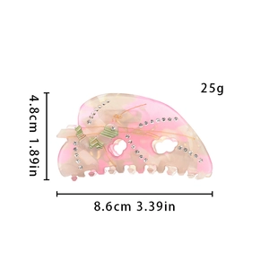 Detailed view of hair claw clip dimensions 8.6cm length with pink marble pattern and bow