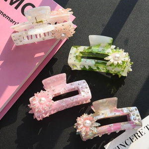 Set di quattro pinze per capelli floreali in acetato con perle e strass su sfondo nero