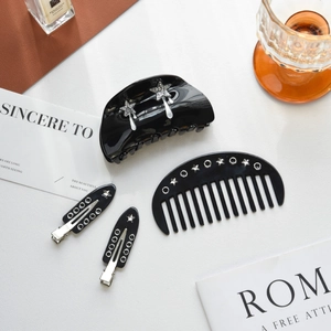 Elegant 4-piece set of black acetate hair clips with silver star patterns for women
