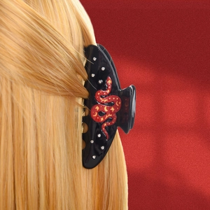 Elegant black snake hair claw clip with red pattern and rhinestones on gold hair