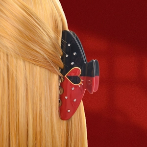 Elegant poker-style black and red acetate hair claw with rhinestones on blonde hair