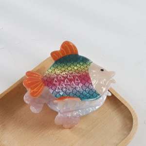 Vue détaillée d'une pince à cheveux en acétate en forme de poisson coloré avec dégradé