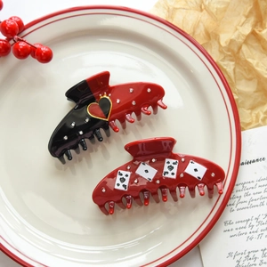 Detailed view of acetic acid hair claws with poker heart patterns and rhinestones
