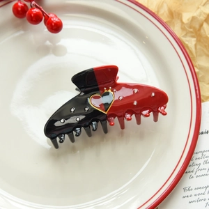 Detail of creative heart poker hair claw clip with rhinestones and elegant gold trim