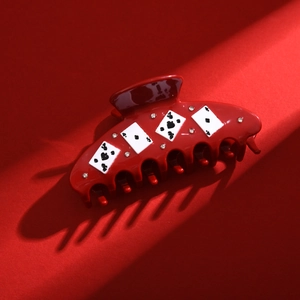 Close-up of red acetic acid hair claw clip with poker pattern and rhinestone details