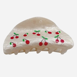 Detail view of acetate cherry hair claw clip with pearl white marble texture