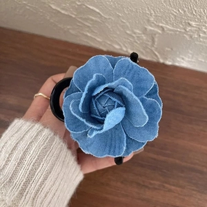 Detail view of the blue denim camellia flower hair claw clip with vintage frayed petal edges