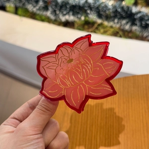 Gros plan détaillé d'une pince à cheveux en forme de lotus rouge aux lignes dorées