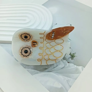 Pince à cheveux chouette en acétate blanc perle et ambre ornée de strass brillants