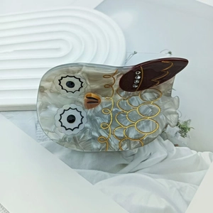 Détail de la pince à cheveux hibou en acétate avec strass brillants et texture marbrée