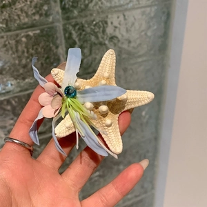 Gros plan détaillé d'une pince à cheveux étoile de mer avec fleurs en soie et gemme