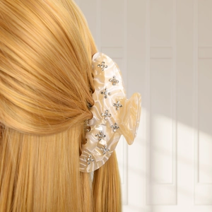 Detail view of acetate shark clip with rhinestones used on long blonde hair