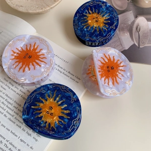 Set of 4 sun-patterned acetate hair claws in pearl white and navy blue with gold accents