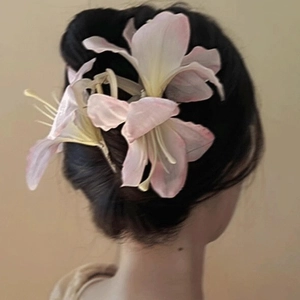 Pink gradient lily flower hair claw clip shown on model for elegant hairstyle