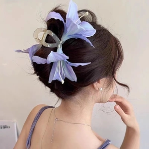 Elegant purple lily flower hair claw clip with gradient petals shown on back of hair