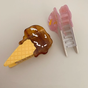 Detail of cream cone hair clips in chocolate brown and strawberry pink acetate finishes